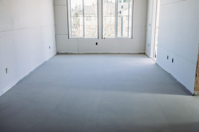 Cured smooth gypsum concrete floor in an empty sunlit room