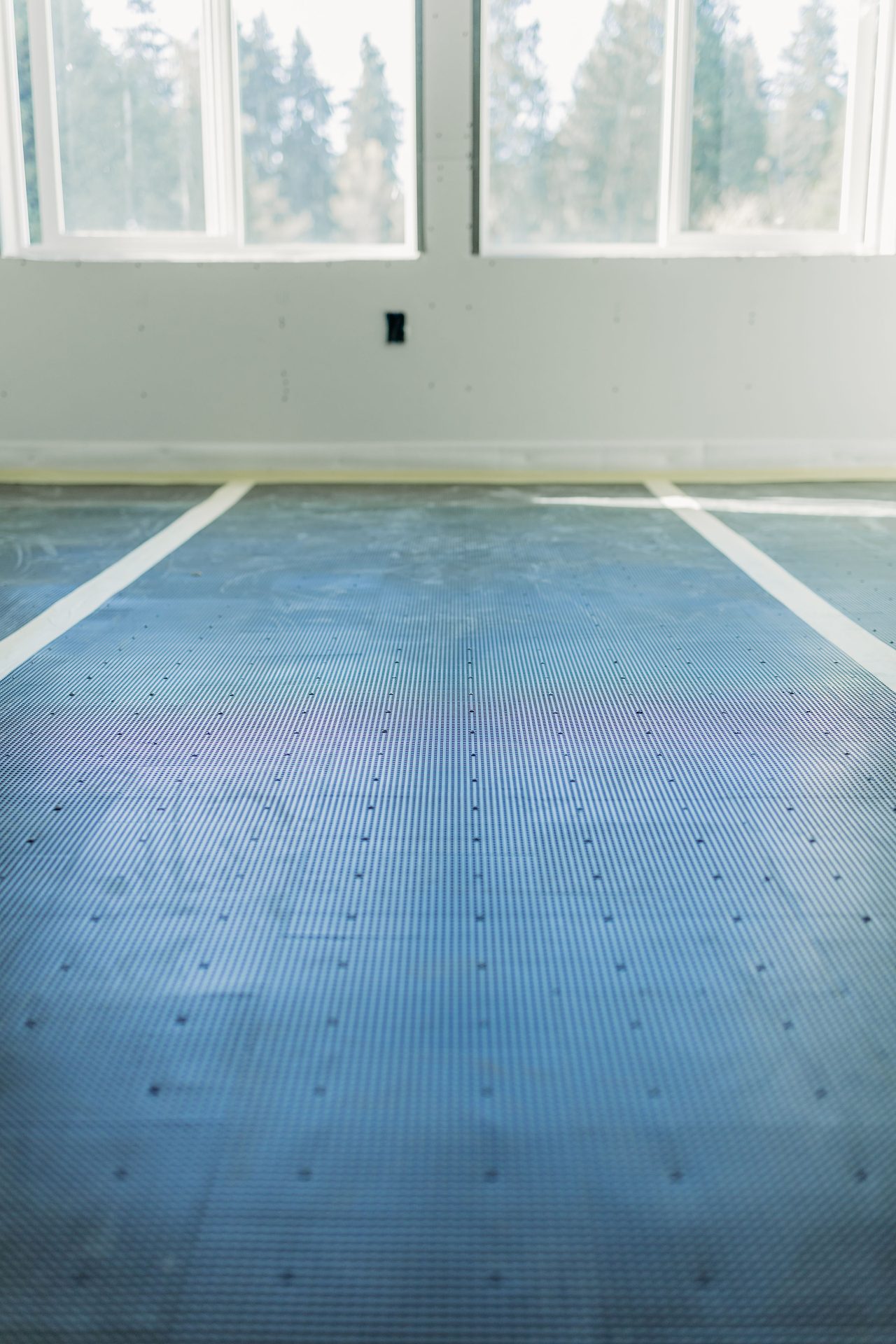 Blue acoustic sound mat rolled out with taped seams before the pour