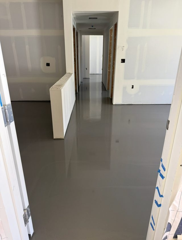 Freshly poured self-leveling floor flowing through a framed hallway